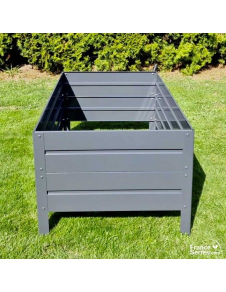 Les pieds du bac de culture sans fond sont enterrés pour fixer la jardinière au sol